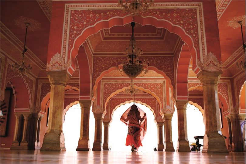 Rajasthan mit allen Sinnen Frau im Indischen Palast der Winde Jaipur
